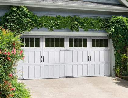 This is an image of a white Amarr Classica carriage house garage door with windows.