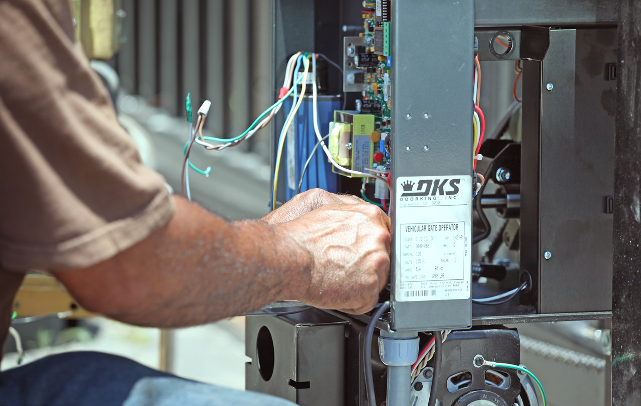 This is an image of a man repairing a driveway gate opener in Orange County CA.