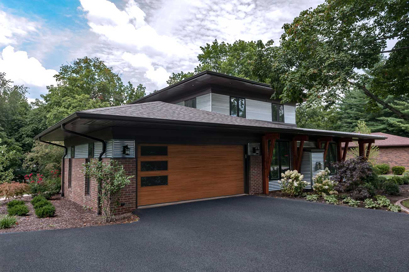 This is an image of a faux wood steel garage doors with windows in a contemporary style.