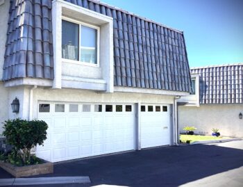 This is the after image of a white Wayne Dalton steel garage door with tinted windows installed in Dana Point, CA.