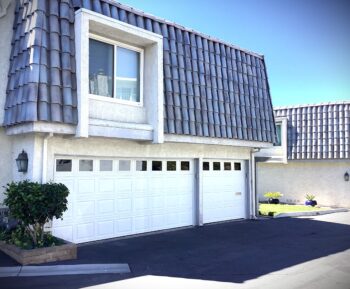 This is the after image of a white Wayne Dalton steel garage door with tinted windows installed in Dana Point, CA.