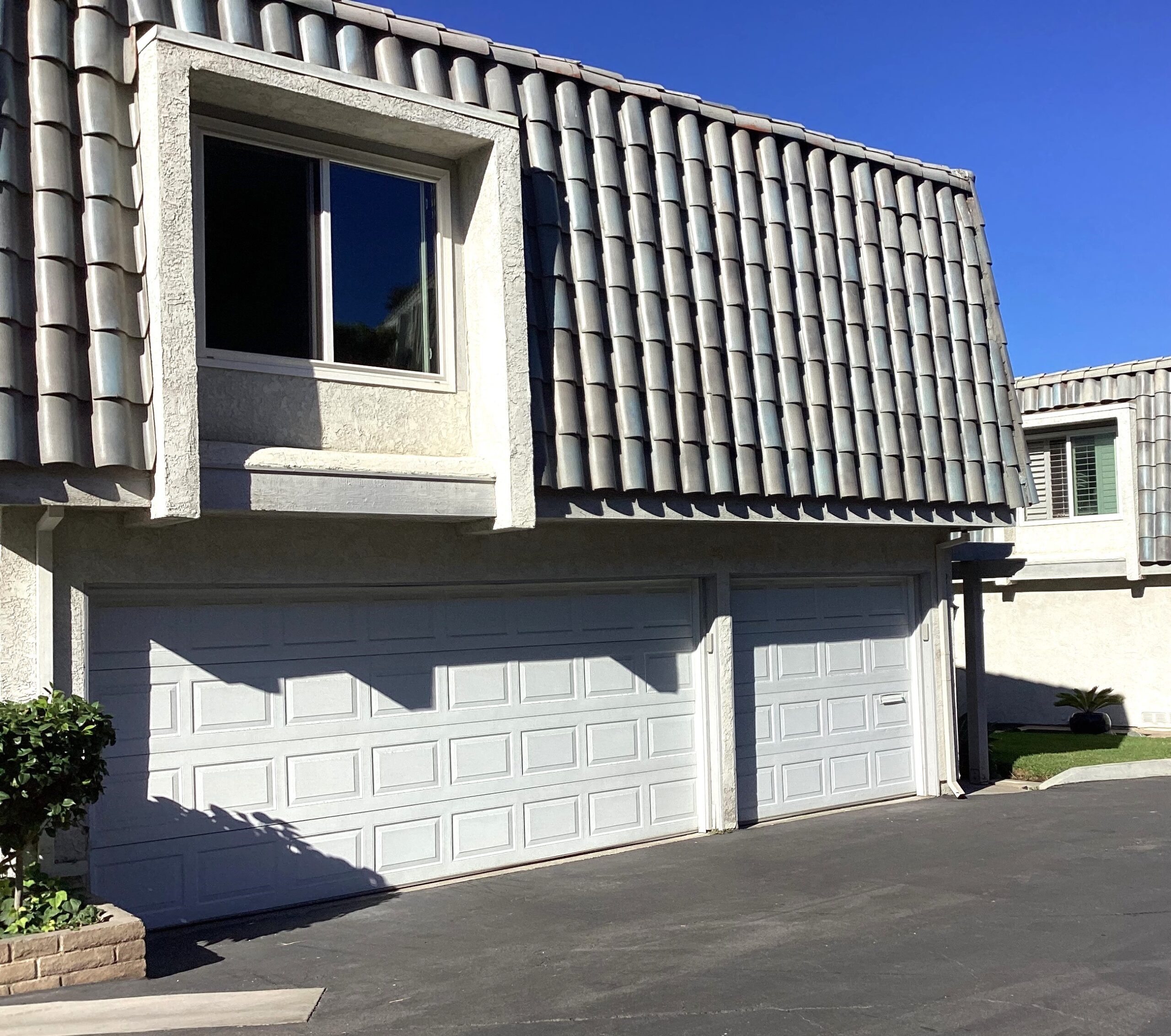 This is the before image of a white Wayne Dalton steel garage door with tinted windows installed in Dana Point, CA.