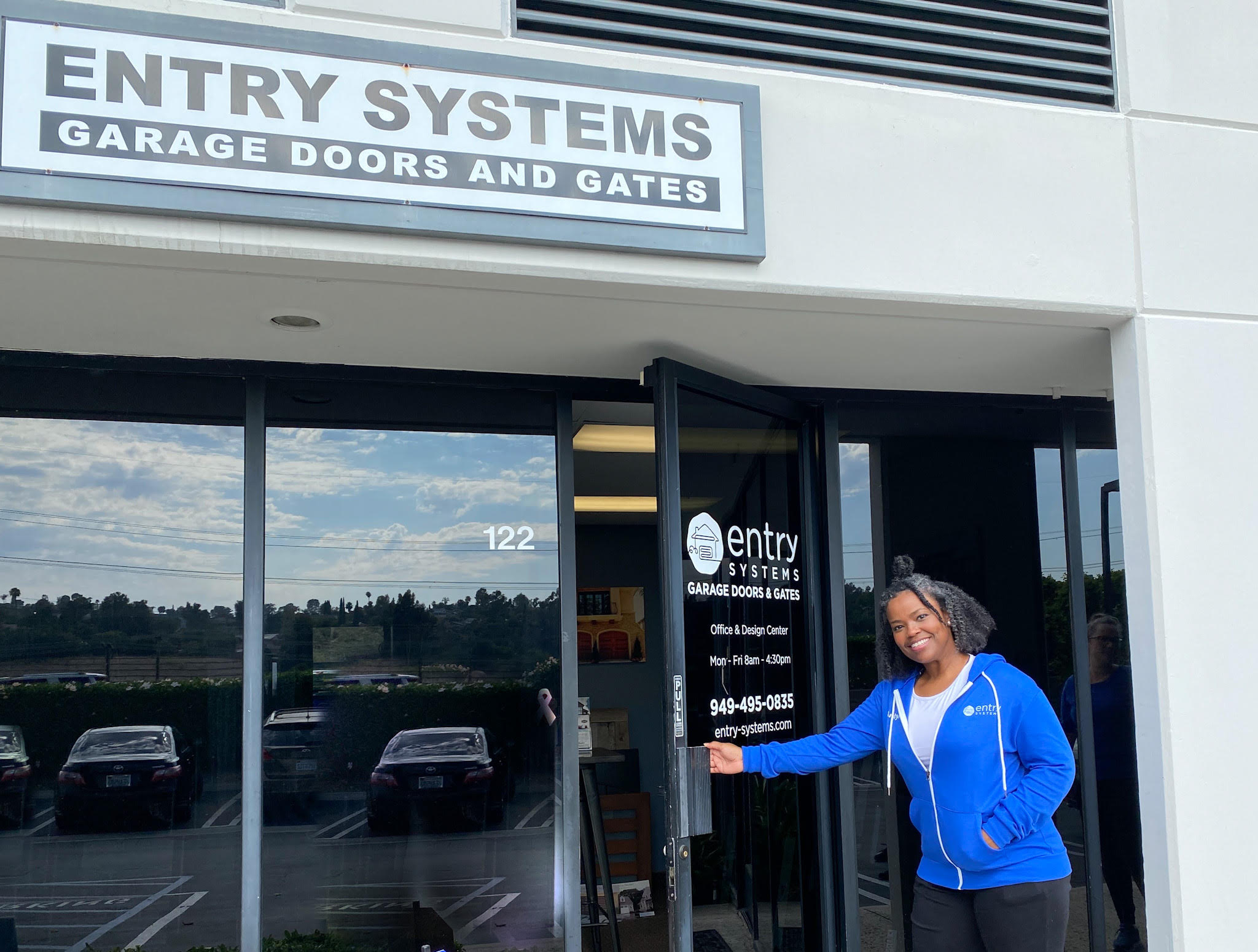 This is an image of Entry Systems employee opening the door of their Laguna Hills garage door showroom