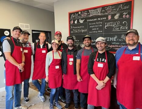 Group of Volunteers at Bracken's Kitchen in Orange County, CA wearing aprons while doing meal prep.
