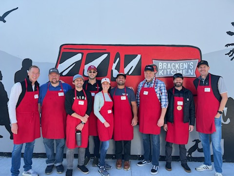 Group of Volunteers at Bracken's Kitchen in Orange County, CA wearing aprons while doing meal prep. This is an outside group pic.