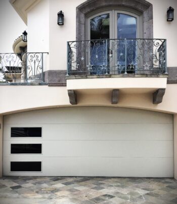 This is a beige flush modern garage door replacement in Newport Beach, CA.