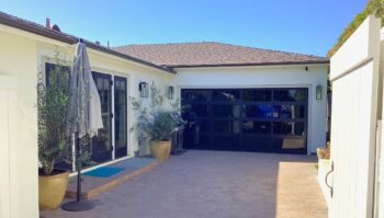 This is the after image of a modern black garage door installation in Laguna Beach, CA.
