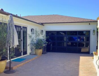 This is the after image of a modern black garage door installation in Laguna Beach, CA.