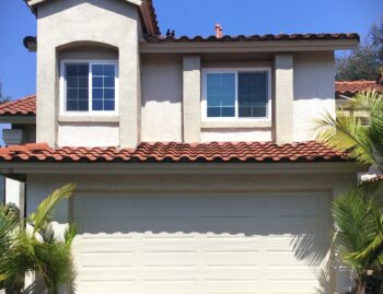 This is the after image of a garage door replacement in Rancho Santa Margarita, CA. It is a tan long panel garage door with no windows.
