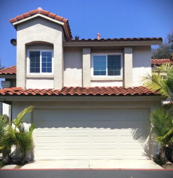 This is the after image of a garage door replacement in Rancho Santa Margarita, CA. It is a tan long panel garage door with no windows.