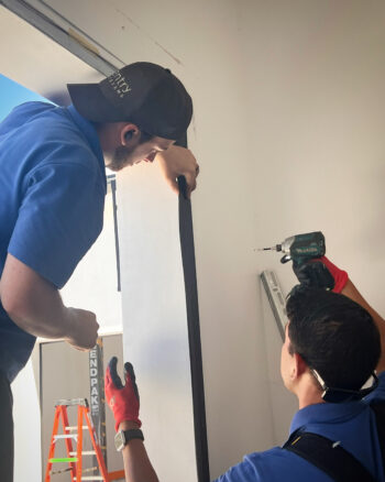 Image of garage door technician installing black door stop.