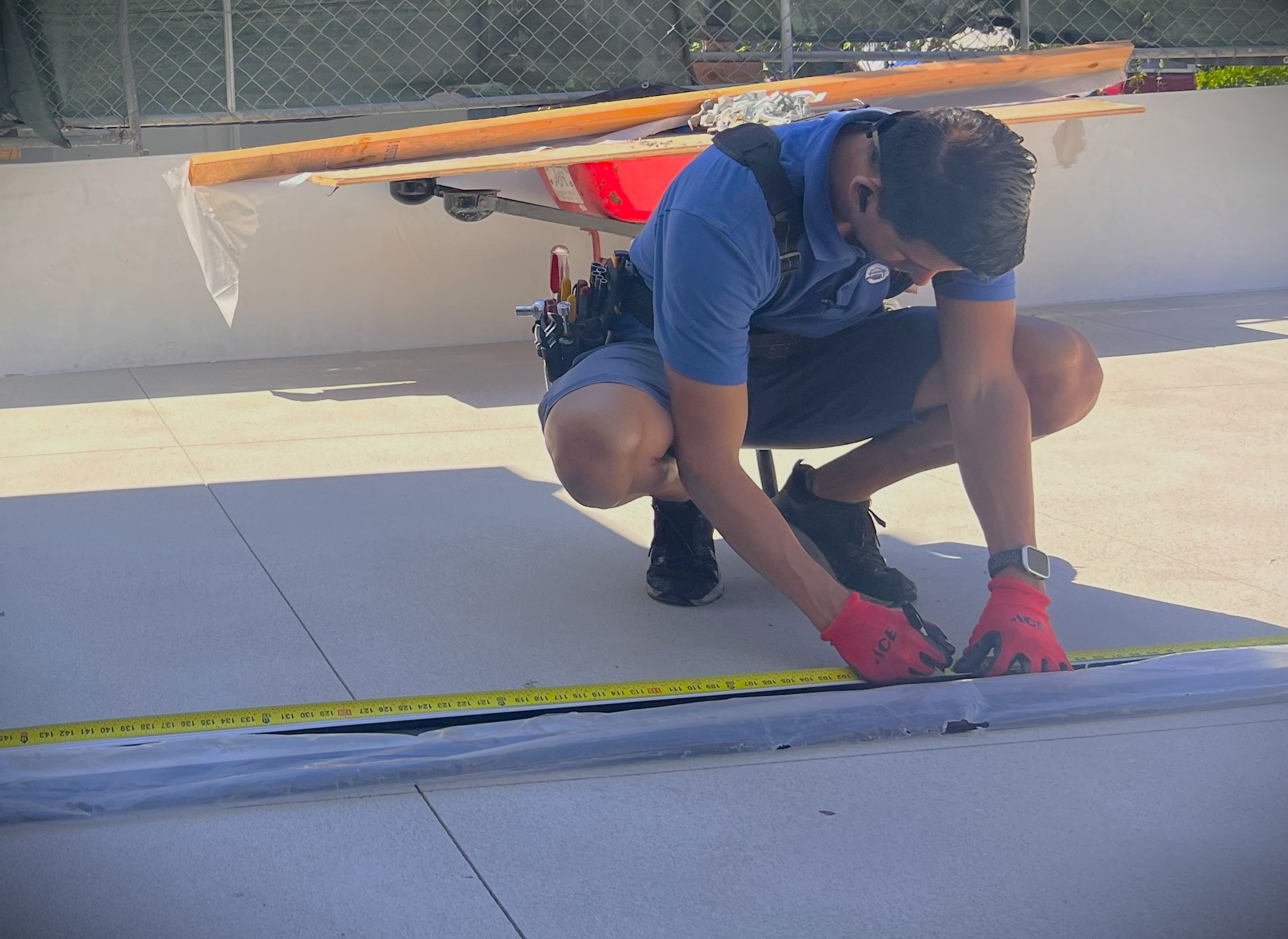 Garage door installer measuring weather stripping for cut