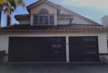 dark oak faux wood garage door with vertical windows in Dana Point after retrofit installation