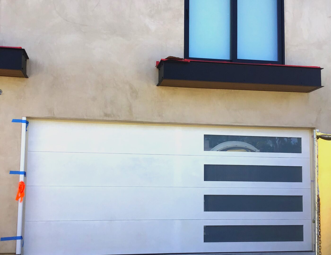 White modern flush garage door with horizontal windows in Laguna Beach, CA