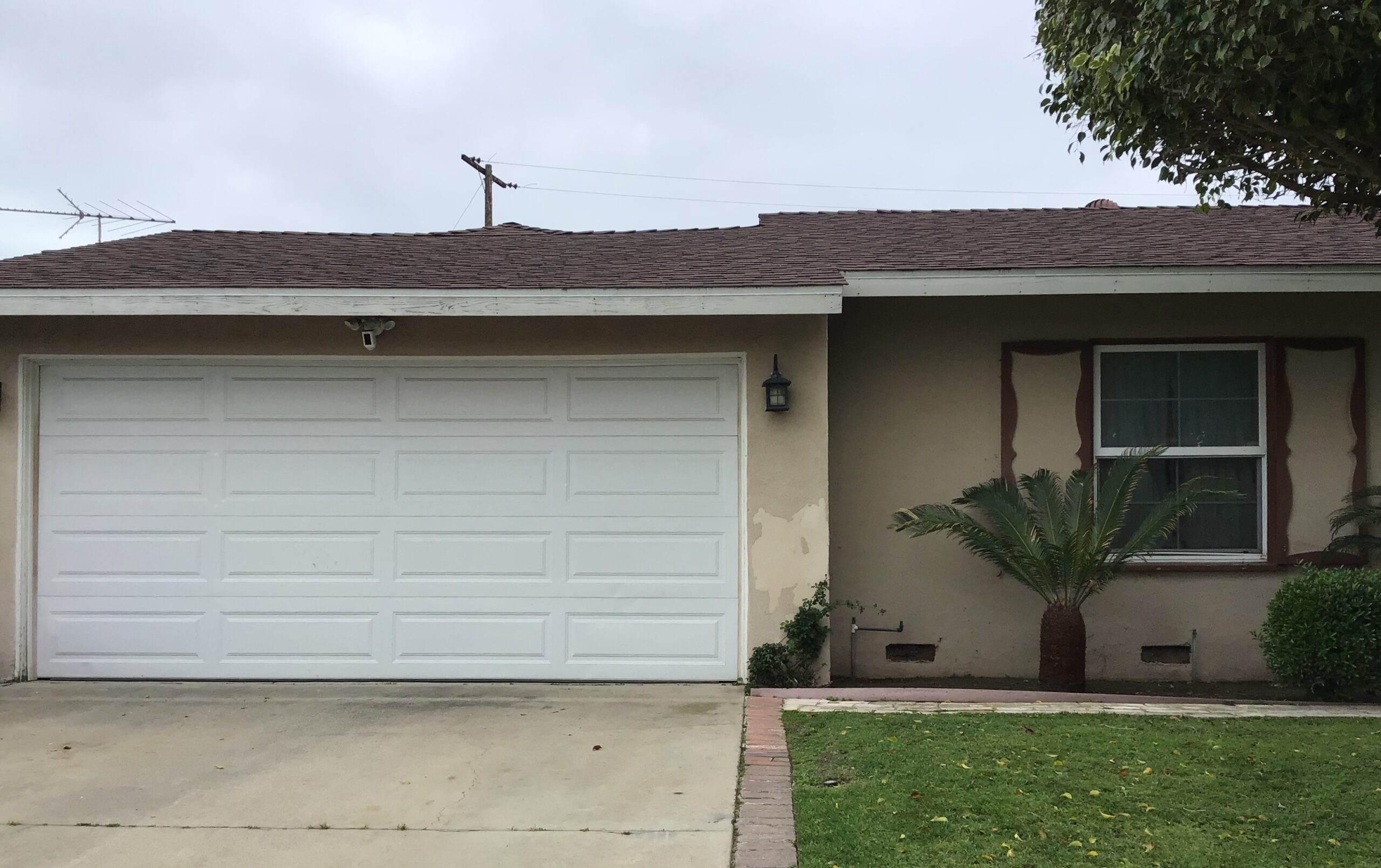 white long panel garage door installation before photo in Garden