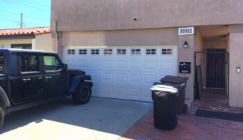 Almond color garage door with short panel design and windows in San Juan Capistrano, CA