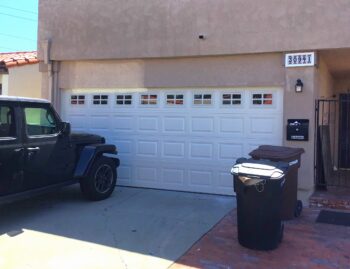 Almond color garage door with short panel design and windows in San Juan Capistrano, CA