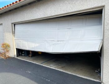 steel garage door crumpled after being hit by car in Laguna Niguel