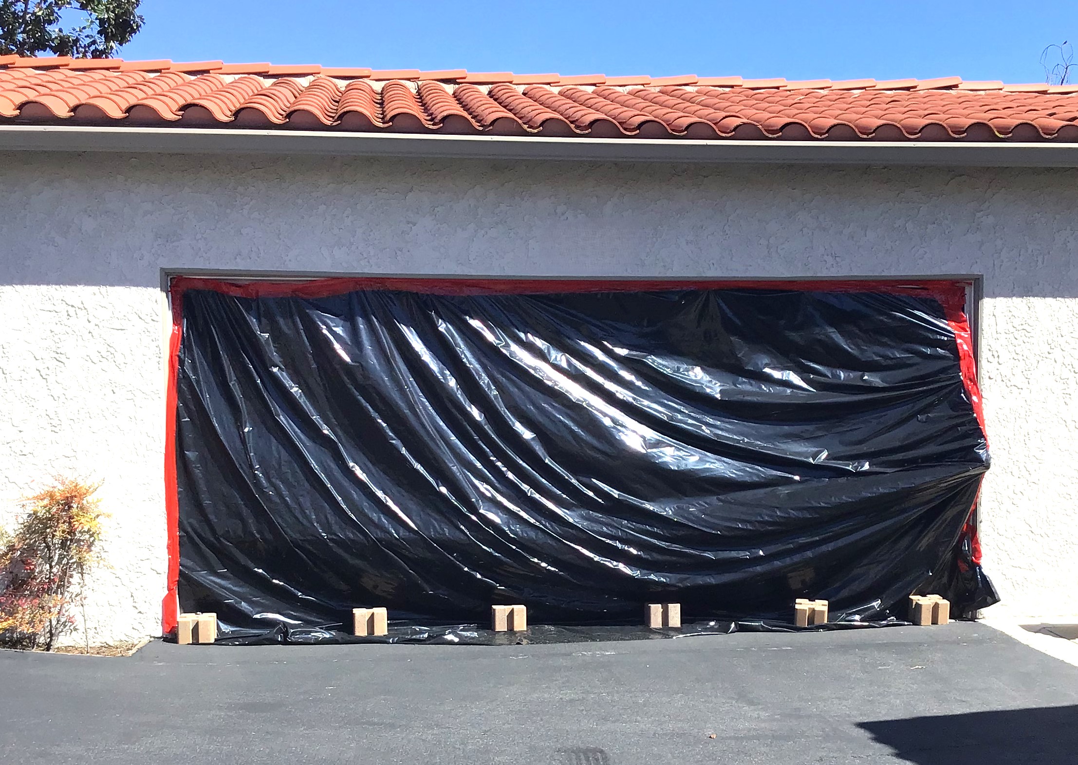 garage door covered in black plastic after being hit by car in Laguna Niguel, CA