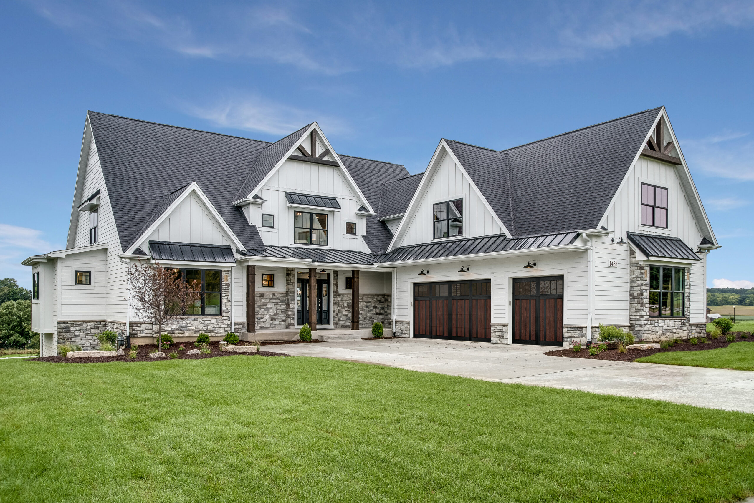 Large house with steep roof and side entry three car garage overlay garage door