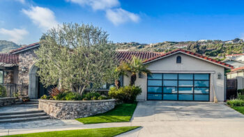 white glass garage door after installation in dana point with hills behind