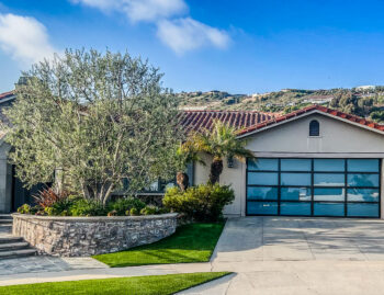 white glass garage door after installation in dana point with hills behind