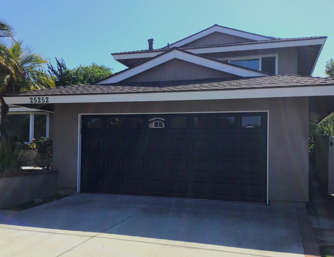 black traditional garage door on brown house