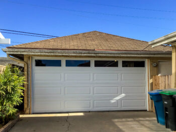 White long panel traditional steel garage door with windows in San Clemente new retrofit