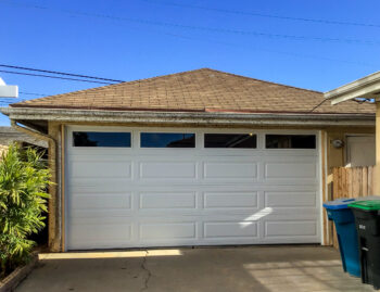 White long panel traditional steel garage door with windows in San Clemente new retrofit