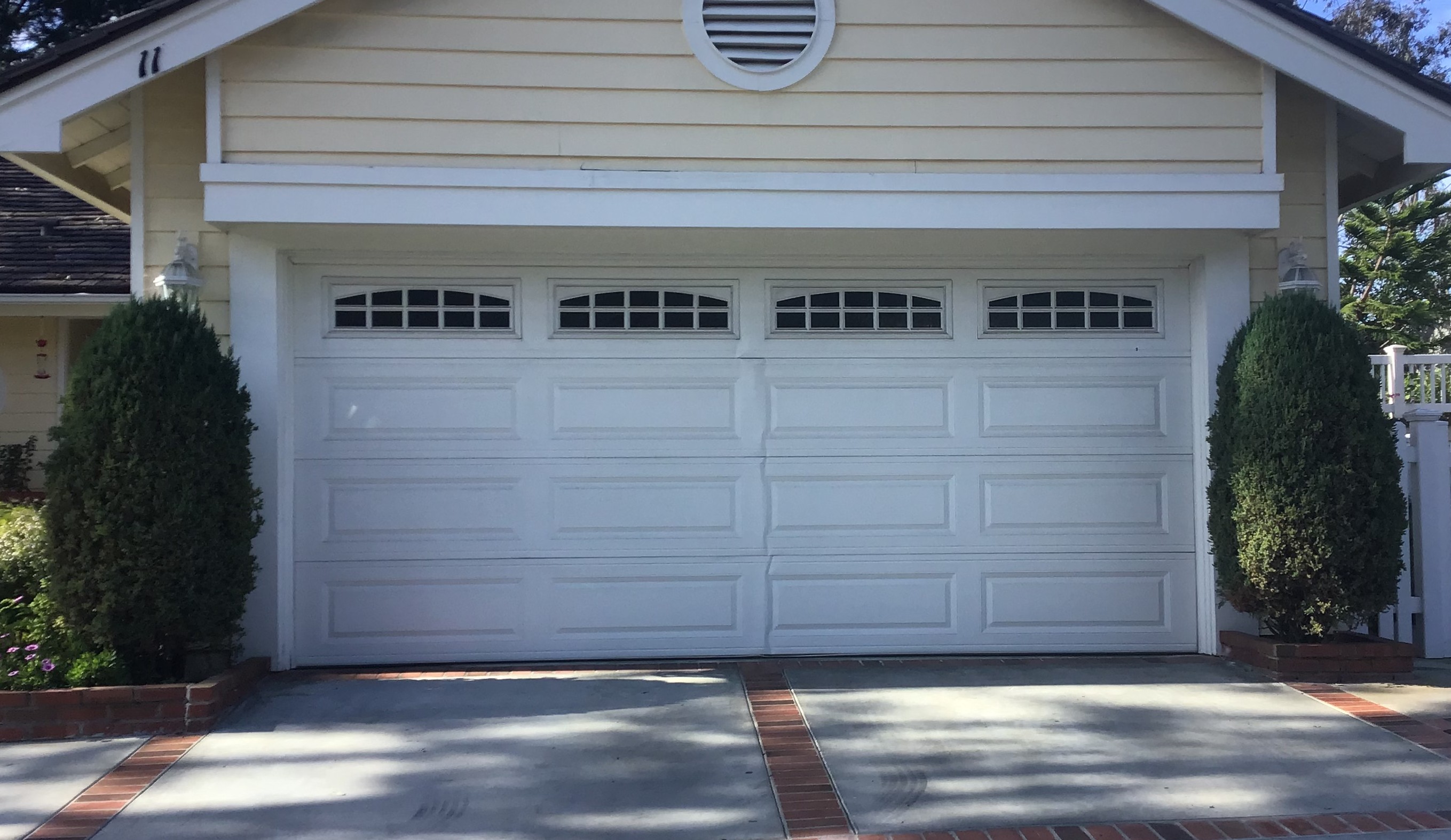 white damaged garage door in Laguna Niguel before replacement