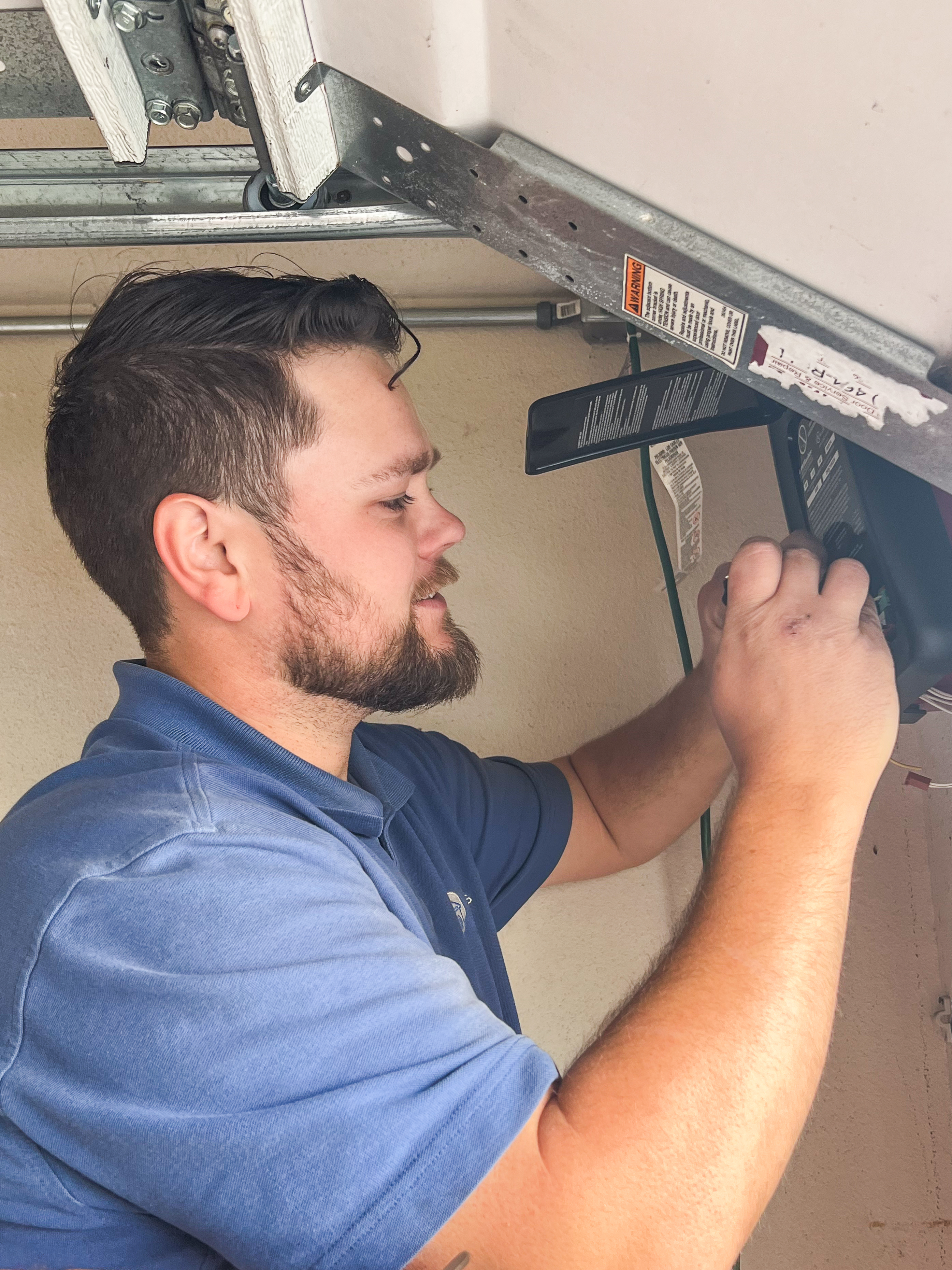 garage door technician working on opener